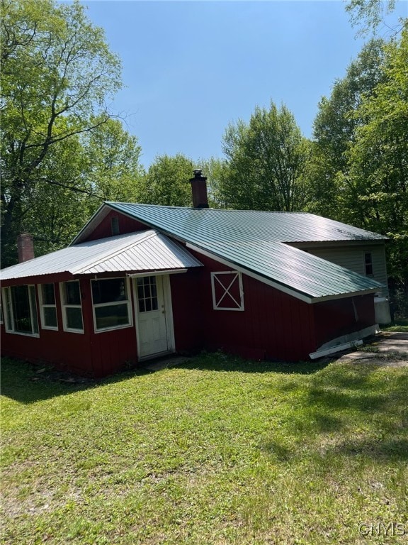 381 French Rd, Morehouse, NY 13324 - view of front of house featuring a chimney, a front lawn, and metal roof