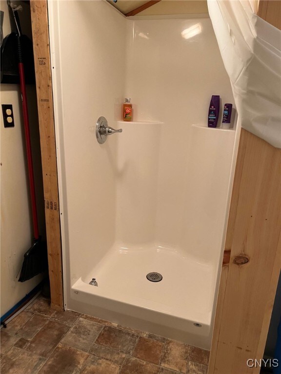 381 French Rd, Morehouse, NY 13324 - full bathroom with a shower stall and stone finish flooring