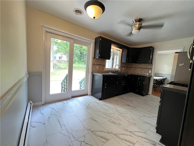 793 Helendale Rd, Irondequoit, NY 14609 - kitchen featuring dark cabinets, light marble finish floors, a ceiling fan, a baseboard heating unit, and freestanding refrigerator
