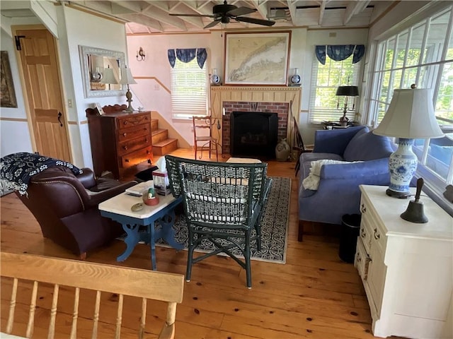 14415 Oak Orchard On The Lk, Carlton, NY 14571 - living area featuring light wood-style flooring, a ceiling fan, a brick fireplace, stairway, and beamed ceiling