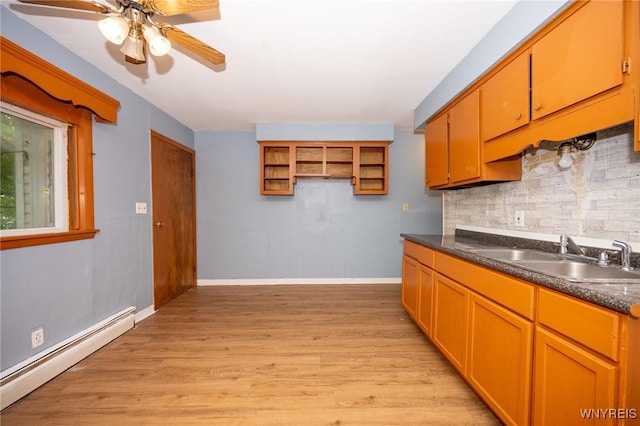 965 Walden Ave, Buffalo, NY 14211 - kitchen with baseboard heating, a sink, ceiling fan, dark countertops, and decorative backsplash