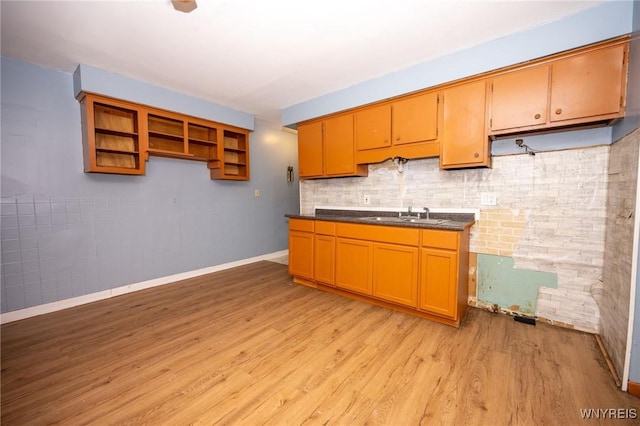 965 Walden Ave, Buffalo, NY 14211 - kitchen featuring light wood-style floors, baseboards, dark countertops, a sink, and backsplash
