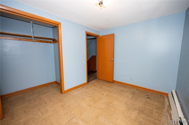 965 Walden Ave, Buffalo, NY 14211 - unfurnished bedroom featuring a baseboard radiator, baseboards, and a closet