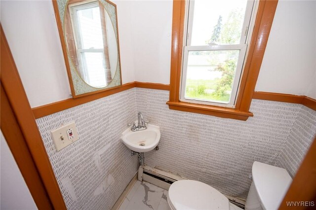 965 Walden Ave, Buffalo, NY 14211 - bathroom with toilet, plenty of natural light, a wainscoted wall, baseboard heating, and a sink