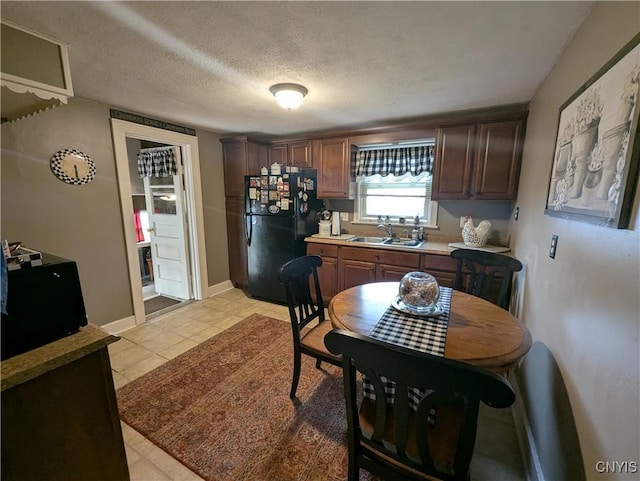 311 Raphael Ave, Salina, NY 13211 - kitchen with freestanding refrigerator, a sink, baseboards, light tile patterned floors, and a textured ceiling