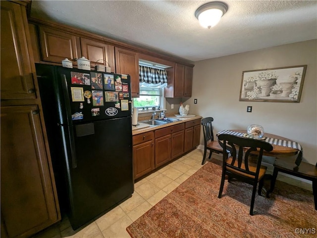 311 Raphael Ave, Salina, NY 13211 - kitchen featuring freestanding refrigerator, a sink, a textured ceiling, light tile patterned flooring, and light countertops