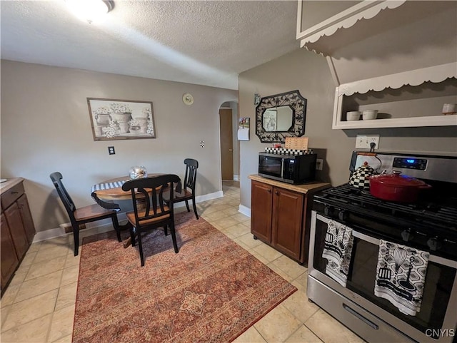 311 Raphael Ave, Salina, NY 13211 - kitchen with stainless steel gas range, black microwave, arched walkways, a textured ceiling, and light countertops