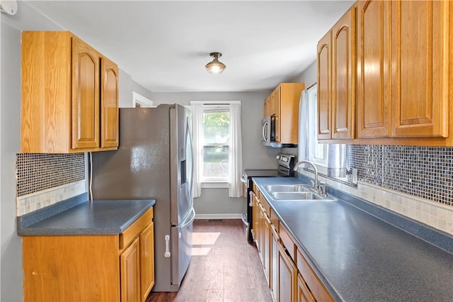 43 Hager Rd, Greece, NY 14616 - kitchen with stainless steel appliances, a sink, dark countertops, dark wood-type flooring, and tasteful backsplash