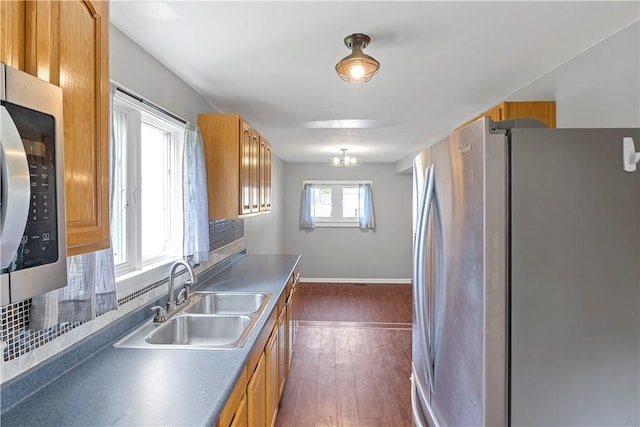43 Hager Rd, Greece, NY 14616 - kitchen featuring stainless steel appliances, a sink, dark wood-style flooring, baseboards, and brown cabinets