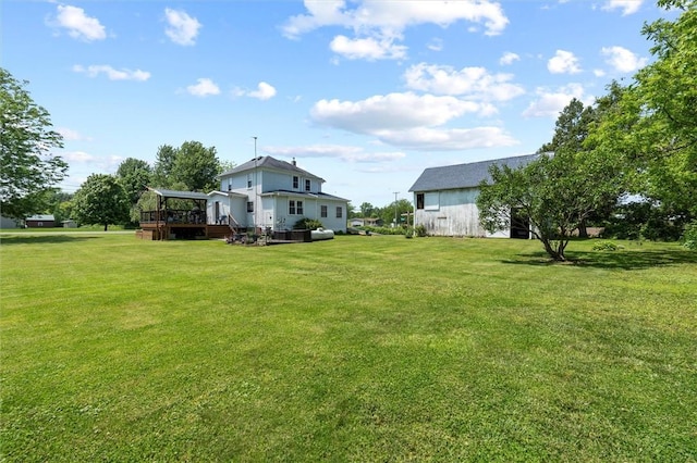 13385 Seneca St, Savannah, NY 13146 - view of green lawn featuring a wooden deck, an outdoor structure, and a barn