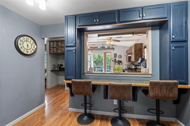 13385 Seneca St, Savannah, NY 13146 - bar area with light wood finished floors, baseboards, and ceiling fan