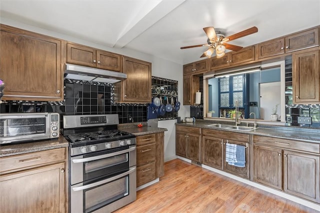 13385 Seneca St, Savannah, NY 13146 - kitchen featuring double oven range, under cabinet range hood, a sink, tasteful backsplash, and a ceiling fan