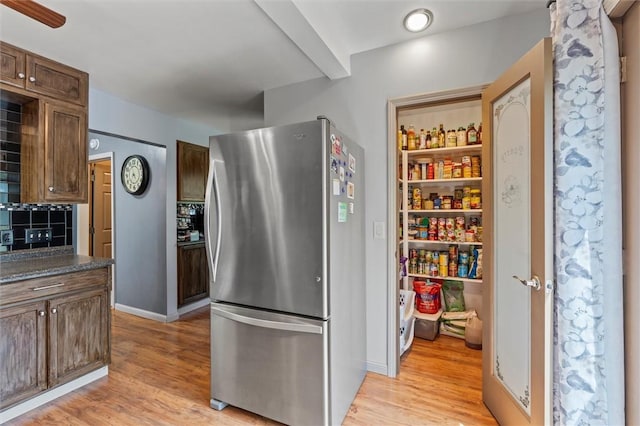 13385 Seneca St, Savannah, NY 13146 - kitchen with freestanding refrigerator, dark countertops, light wood-style flooring, decorative backsplash, and baseboards
