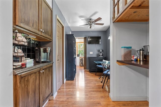 13385 Seneca St, Savannah, NY 13146 - kitchen featuring dark countertops, light wood-style floors, ceiling fan, and baseboards