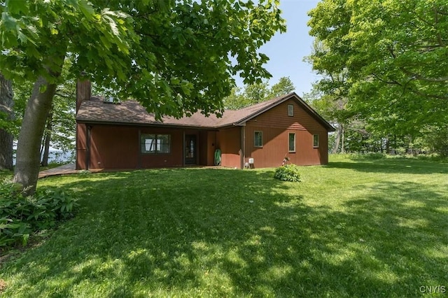 4859 Becker Ln, Lyme, NY 13693 - back of house featuring a chimney and a lawn