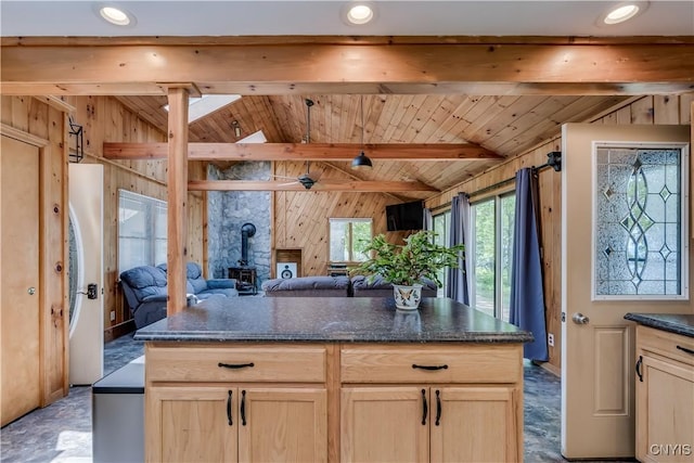 4859 Becker Ln, Lyme, NY 13693 - kitchen featuring a wood stove, wood walls, dark stone counters, open floor plan, and light brown cabinets