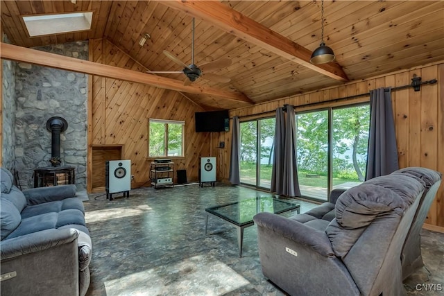 4859 Becker Ln, Lyme, NY 13693 - living area with a wood stove, wood walls, ceiling fan, a skylight, and wooden ceiling