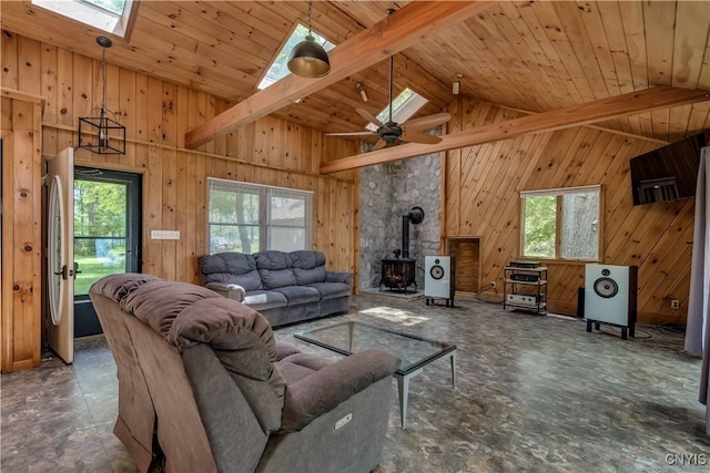4859 Becker Ln, Lyme, NY 13693 - living area with a skylight, healthy amount of natural light, a wood stove, wooden walls, and high vaulted ceiling