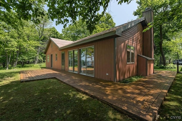 4859 Becker Ln, Lyme, NY 13693 - view of home's exterior featuring a deck, a lawn, and a chimney