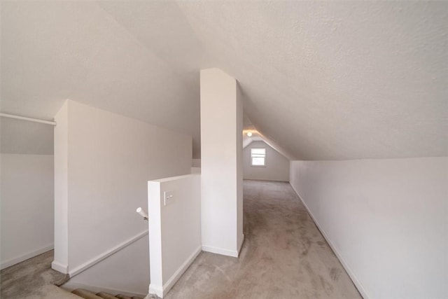 257 Longridge Ave, Greece, NY 14616 - additional living space with vaulted ceiling, light colored carpet, a textured ceiling, and baseboards