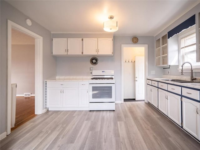 257 Longridge Ave, Greece, NY 14616 - kitchen featuring white gas range oven, white cabinetry, a sink, light countertops, and light wood-type flooring