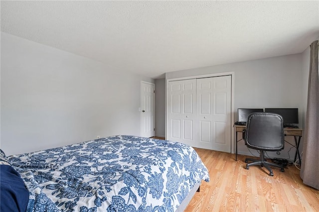 11 Shadow Ln, Gates, NY 14606 - bedroom with light wood finished floors, a closet, and a textured ceiling