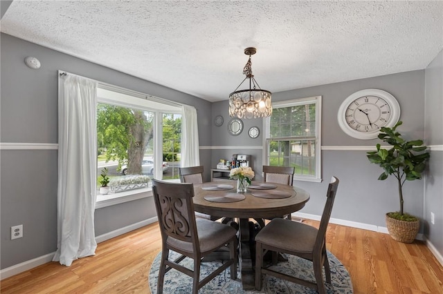 11 Shadow Ln, Gates, NY 14606 - dining space with light wood-style flooring, a textured ceiling, a chandelier, and baseboards