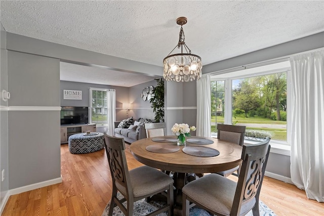 11 Shadow Ln, Gates, NY 14606 - dining space with baseboards, light wood-style flooring, a textured ceiling, a chandelier, and plenty of natural light