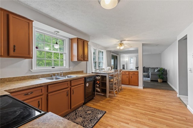 11 Shadow Ln, Gates, NY 14606 - kitchen with dishwasher, a sink, brown cabinets, light wood-style floors, and a textured ceiling