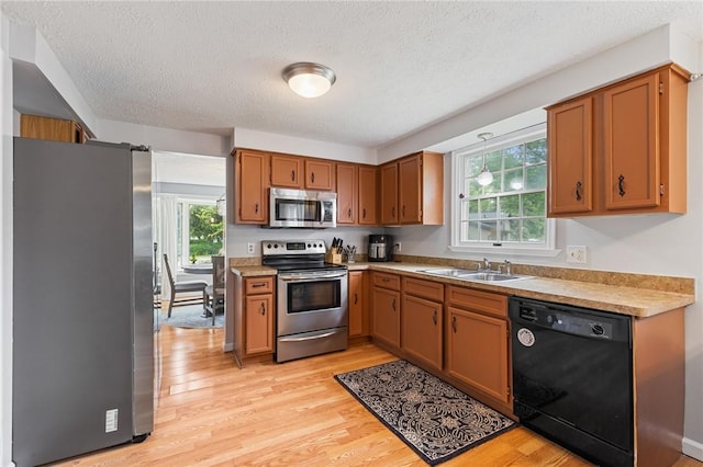 11 Shadow Ln, Gates, NY 14606 - kitchen featuring appliances with stainless steel finishes, a sink, light wood finished floors, a textured ceiling, and light countertops