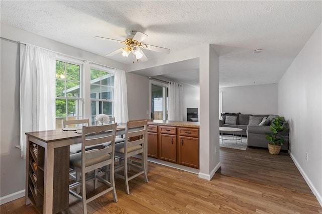 11 Shadow Ln, Gates, NY 14606 - dining space with a textured ceiling, light wood-type flooring, a ceiling fan, and baseboards
