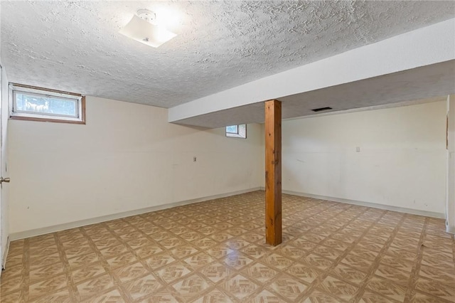 11 Shadow Ln, Gates, NY 14606 - basement featuring a textured ceiling, light floors, and baseboards