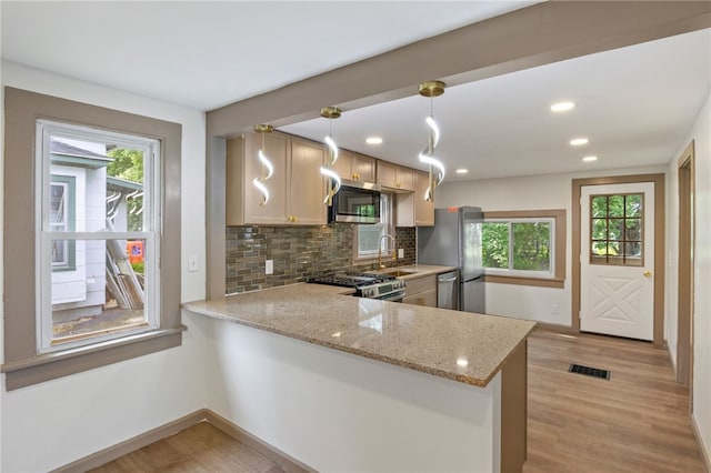74 Clearview Rd, Greece, NY 14616 - kitchen with appliances with stainless steel finishes, baseboards, a peninsula, tasteful backsplash, and light wood-style flooring