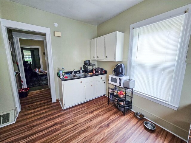 40 Grover St, Rochester, NY 14611 - kitchen with a sink, white microwave, dark wood finished floors, baseboards, and white cabinets