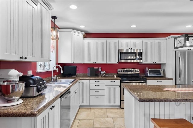 2203 State Route 14 N, Lyons, NY 14489 - kitchen featuring appliances with stainless steel finishes, a sink, decorative light fixtures, white cabinets, and light stone finish flooring