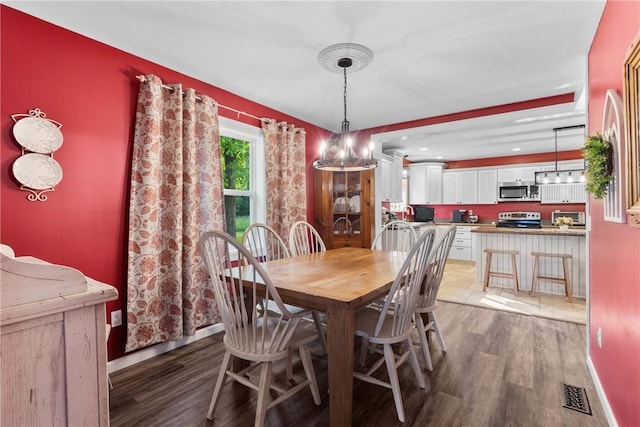 2203 State Route 14 N, Lyons, NY 14489 - dining room featuring wood finished floors, a chandelier, and baseboards