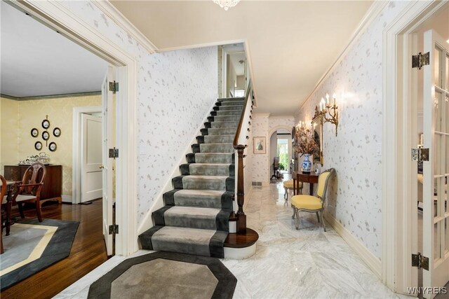 88 Middlesex Rd, Buffalo, NY 14216 - stairs featuring wallpapered walls, arched walkways, ornamental molding, and baseboards