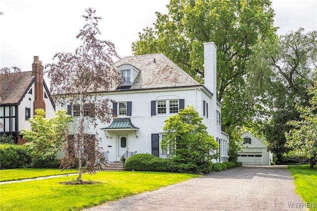 88 Middlesex Rd, Buffalo, NY 14216 - view of front of house with a detached garage, an outbuilding, a chimney, and a front yard