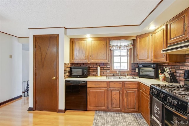 1 Woodstream Dr, Lancaster, NY 14086 - kitchen with black appliances, a sink, under cabinet range hood, light wood-style flooring, and crown molding