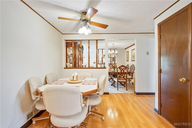 1 Woodstream Dr, Lancaster, NY 14086 - dining area with ceiling fan, light wood-style floors, ornamental molding, baseboards, and a chandelier