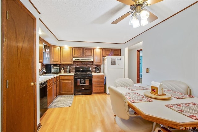 1 Woodstream Dr, Lancaster, NY 14086 - kitchen featuring gas range, freestanding refrigerator, light wood-type flooring, brown cabinets, and dishwasher