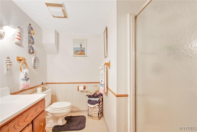 1 Woodstream Dr, Lancaster, NY 14086 - bathroom featuring vanity, a stall shower, toilet, a wainscoted wall, and tile patterned floors