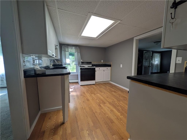 135 Hedgehog Ln, Bradford Town, PA 16701 - kitchen featuring white gas range, dark countertops, a sink, light wood-type flooring, and a drop ceiling