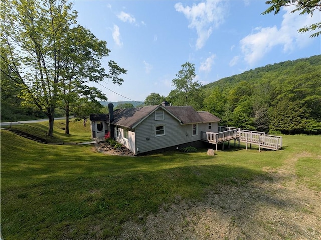 135 Hedgehog Ln, Bradford Town, PA 16701 - rear view of house with a wooden deck, a view of trees, a lawn, and a chimney