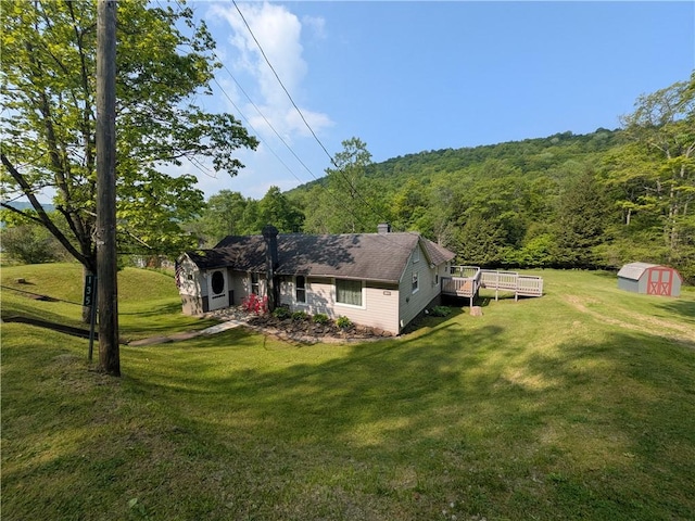 135 Hedgehog Ln, Bradford Town, PA 16701 - view of front facade with a chimney, a wooden deck, a wooded view, and a front yard