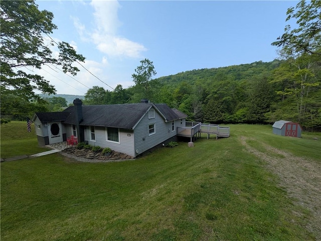 135 Hedgehog Ln, Bradford Town, PA 16701 - view of side of property featuring a wooded view, a deck, a yard, a chimney, and a shingled roof
