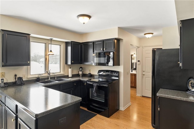 439 Red Apple Ln, Greece, NY 14612 - kitchen with black appliances, a sink, a peninsula, dark countertops, and light wood-style floors