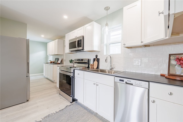 237 Heberle Rd, Irondequoit, NY 14609 - kitchen with appliances with stainless steel finishes, a sink, dark countertops, light wood finished floors, and recessed lighting