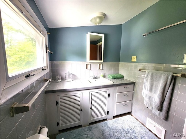 70 W Elizabeth St, Skaneateles, NY 13152 - bathroom with tile walls, vanity, and wainscoting