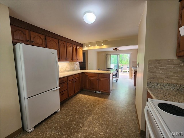 70 W Elizabeth St, Skaneateles, NY 13152 - kitchen with white appliances, tasteful backsplash, a peninsula, light countertops, and rail lighting